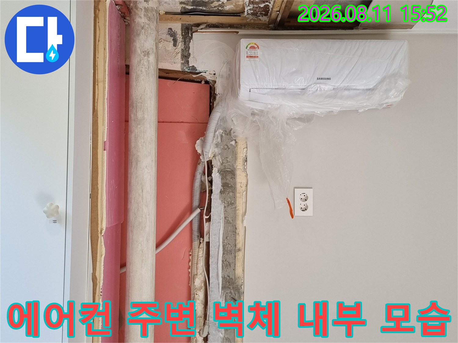 벽지를 제거하고 굴착한 벽면에 분홍색 단열재와 배관이 노출되어 있는 장면