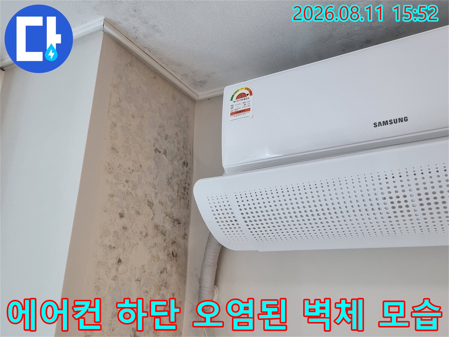 흰색 에어컨 기기와 대조되는 어두운 색상의 벽면 곰팡이-습기 피해 구역