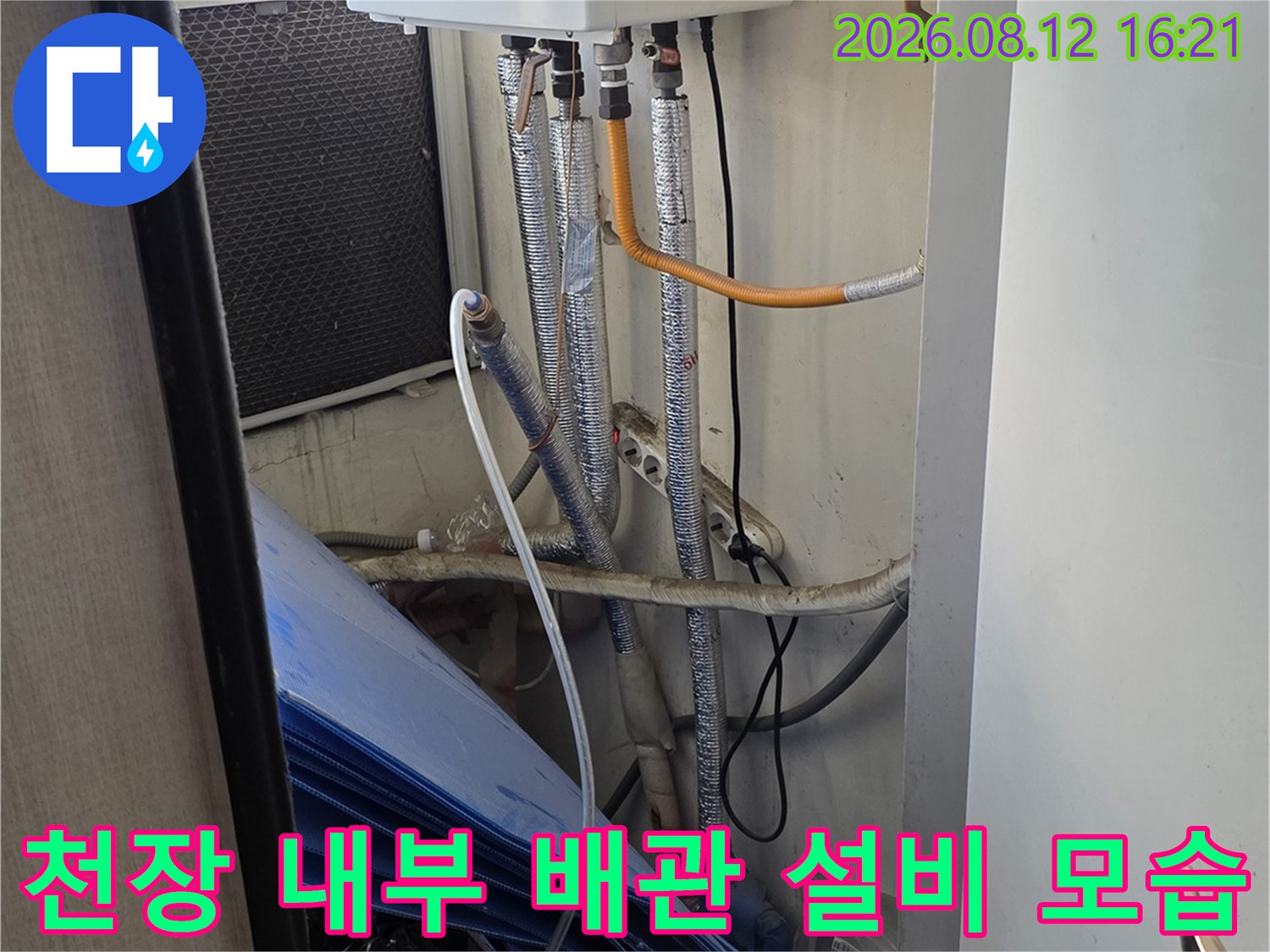 천장 속에 매립된 흰색 장비와 은색 주름관 형태의 배관-설치 전경