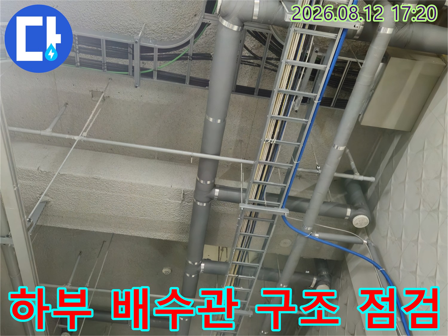 지하 주차장 상부 천장에 노출된 배수 관로와 전기 트레이