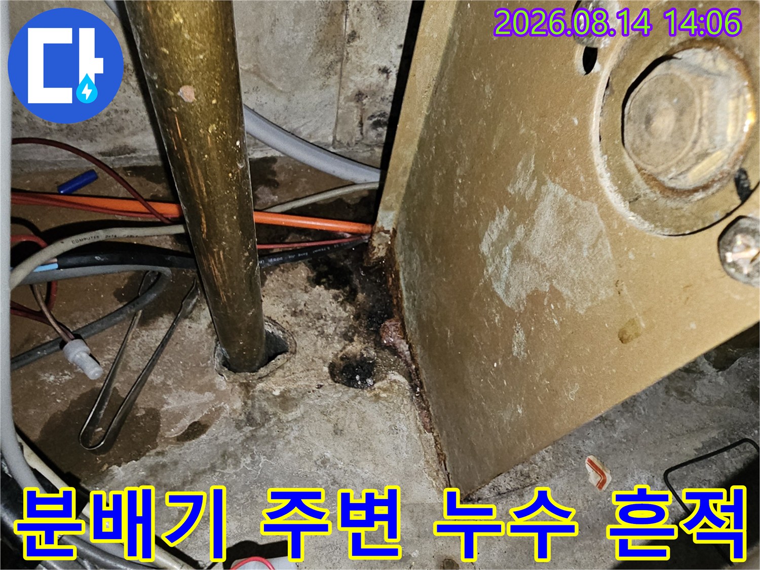 분배기 하단 배관 연결부의 부식된 금속면과 젖은 바닥 상태