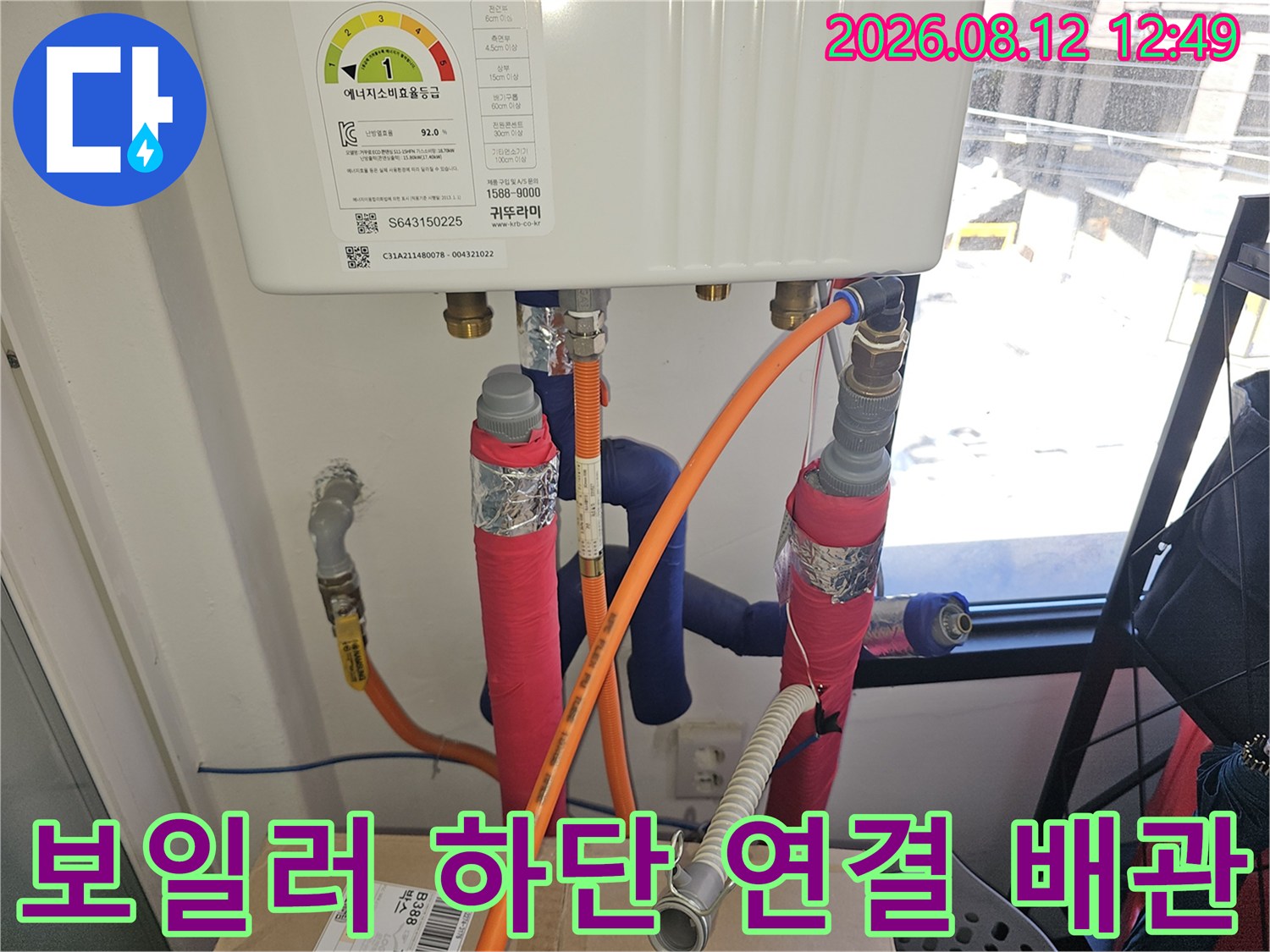 보일러 아래에 위치한 주황색 호스와 보온재로 감싸진 배관들