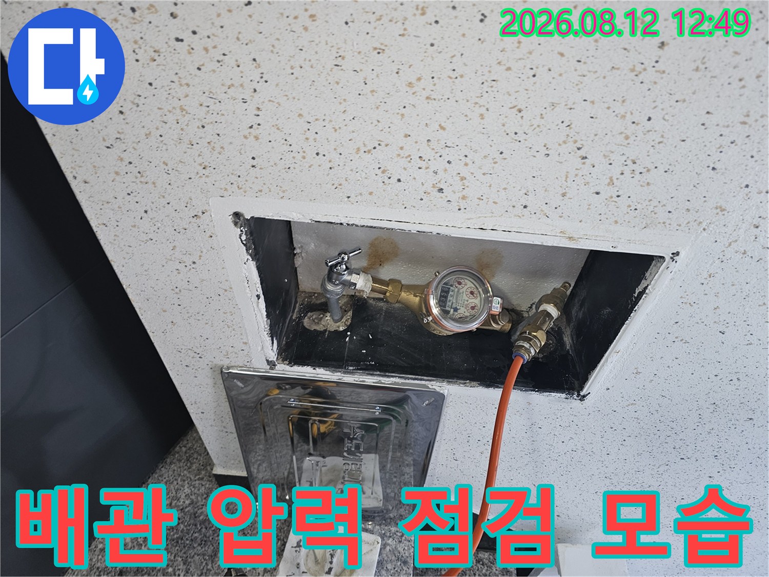 수도 계량기 부근에 압력계를 연결하여 배관의 기밀 상태를 정밀하게 측정하는 장면입니다.