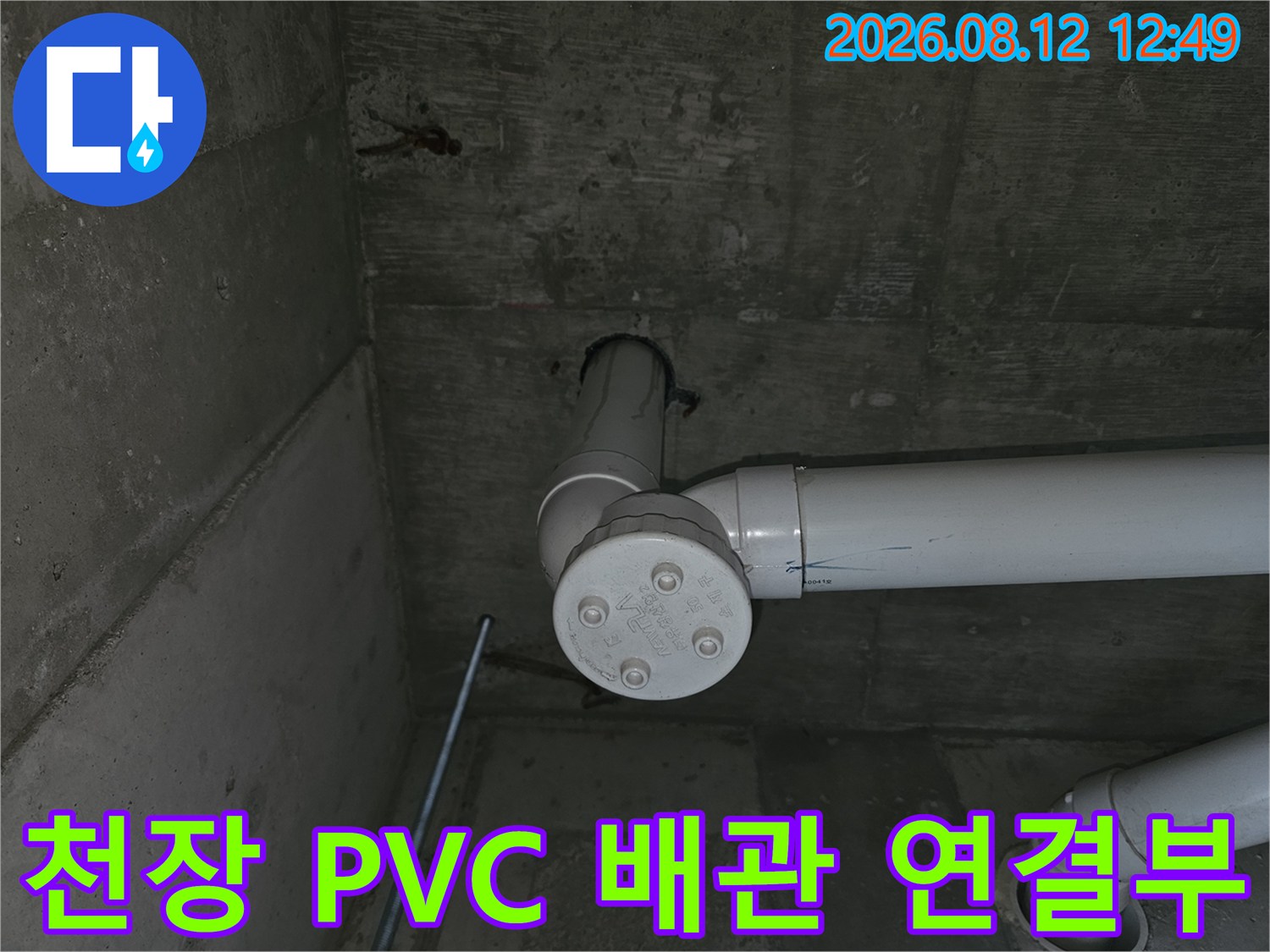 콘크리트 천장에 설치된 하얀색 배관 부속입니다.