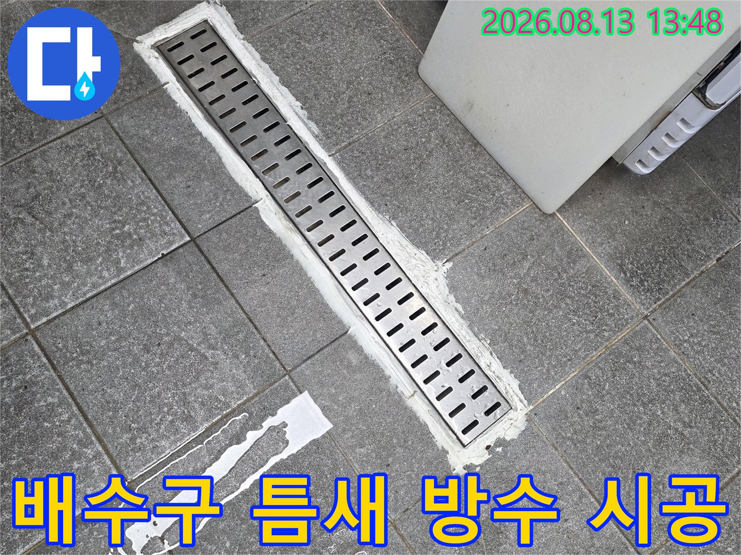 하얀색 보수재를 사용하여 트렌치 배수구 주변의 틈을 메우는 과정입니다.