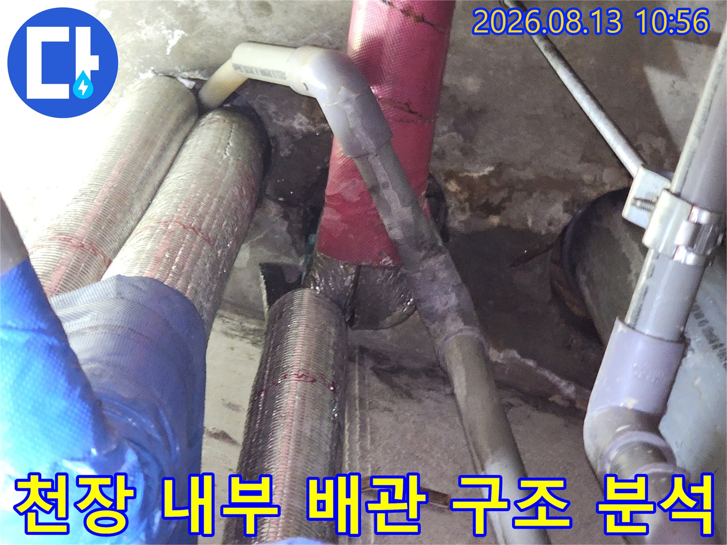 다양한 굵기와 색상의 배관들이 복잡하게 설치된 천장 속 모습