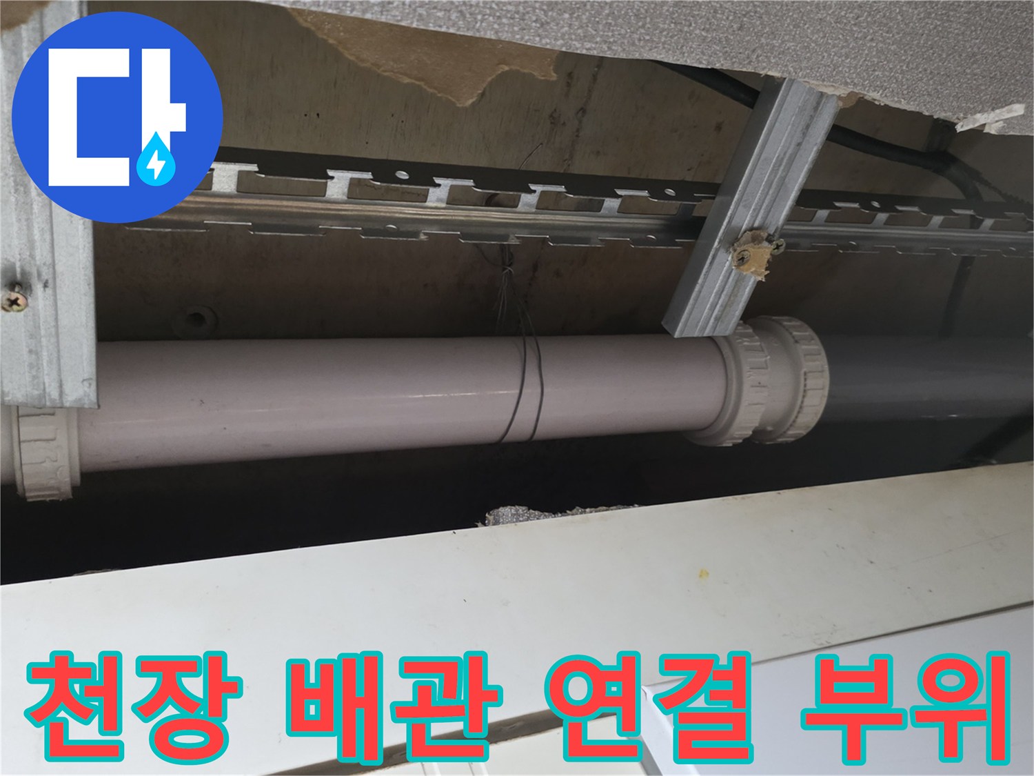 천장 구조물 사이로 노출된 하얀색 PVC 배관과 고정용 금속 프레임
