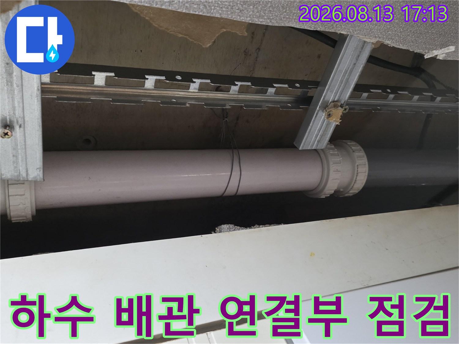 천장 내부 금속 프레임에 고정된 하수 배관의 모습