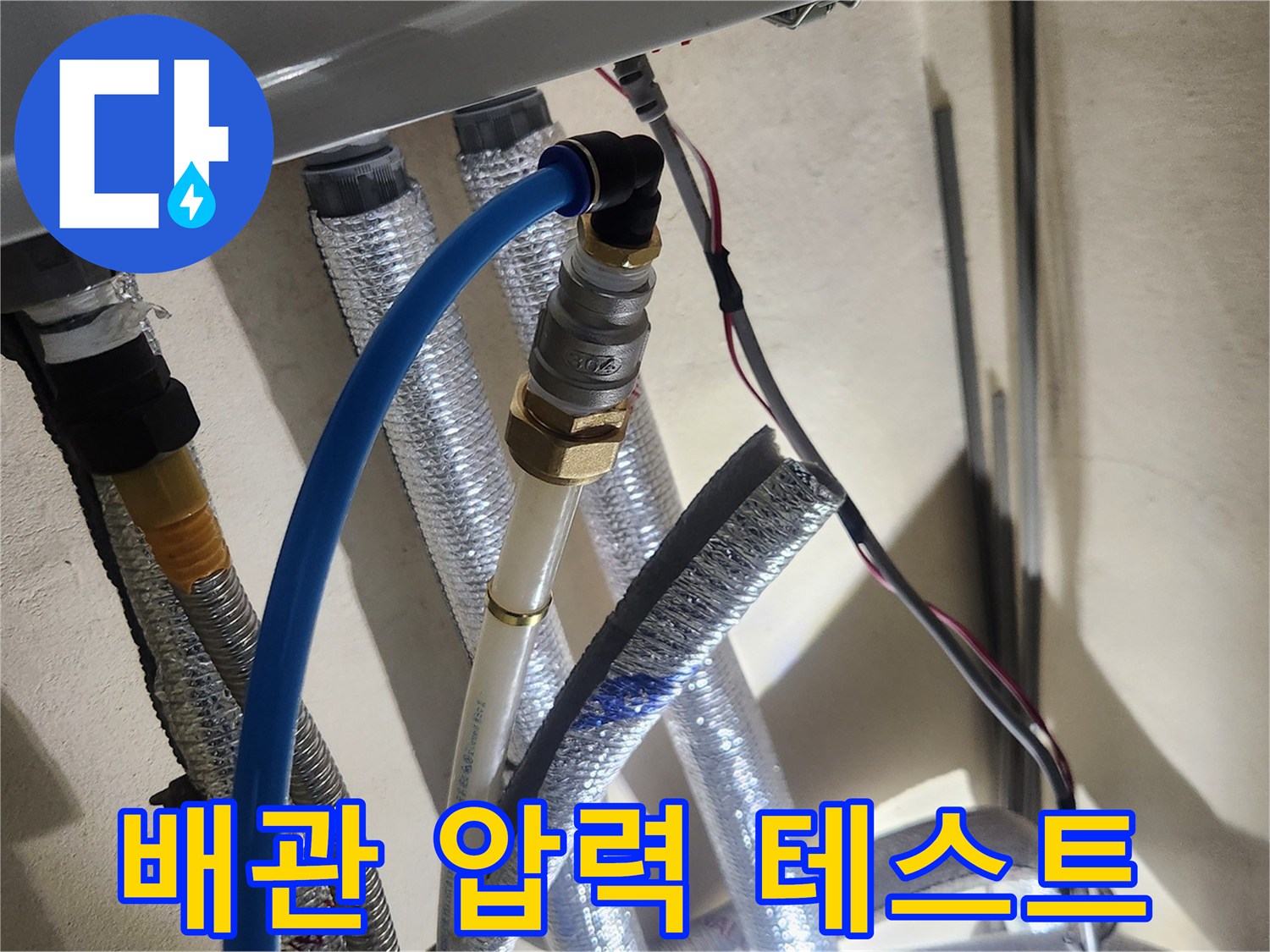 배관 연결 부위에-공압 장비를 설치하여 압력을 주입하는 장면입니다.