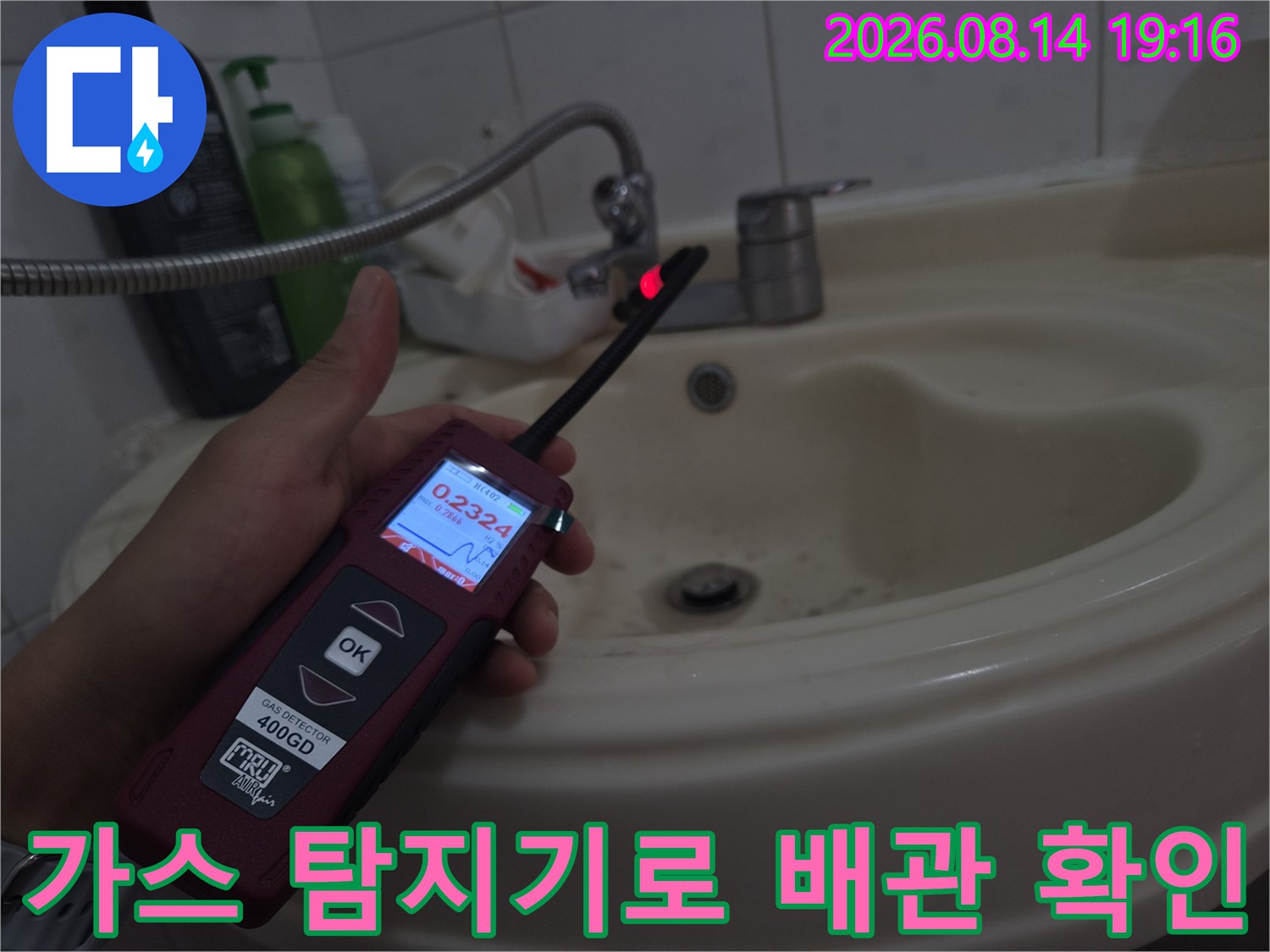 디지털 숫자가 보이는-가스 탐지기를 사용하여-세면대 배관을 점검함