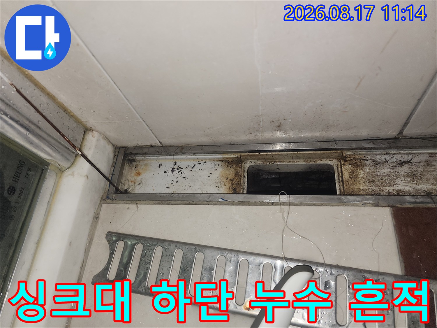 싱크대 아래쪽 배관 주변의 곰팡이와 물자국을 근접 촬영한 사진입니다.