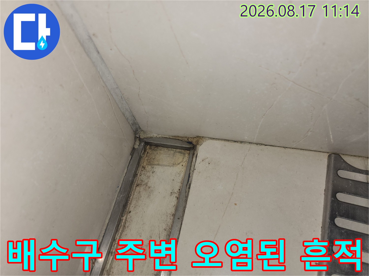 싱크대 하부 타일 틈새에 나타난 습기와 오염된 물자국입니다.