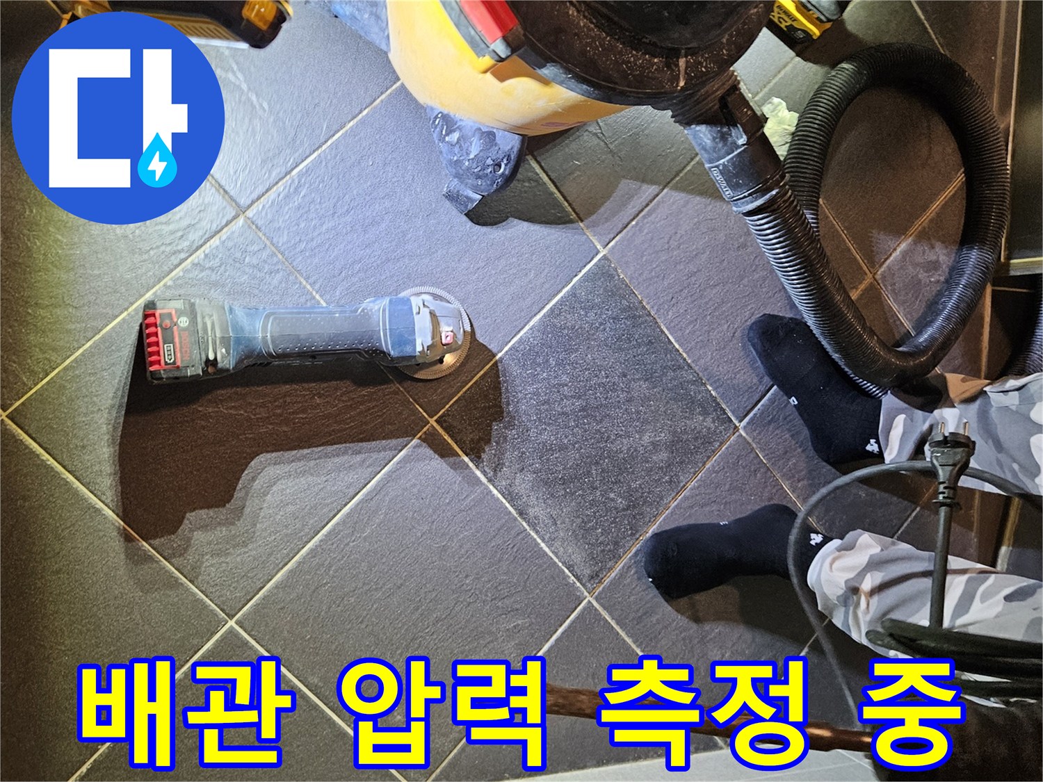 타일 바닥 위에서 진행되는 배관 기밀 시험 과정