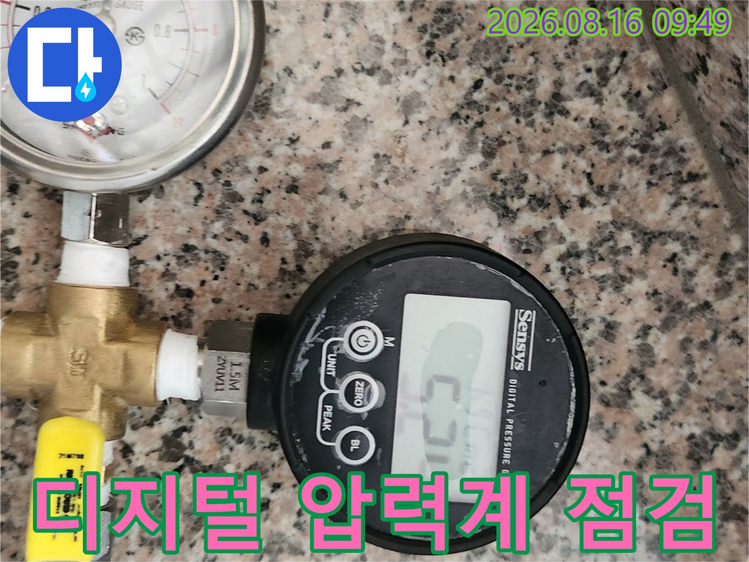 수도 배관의 누수 여부를 확인하기 위해 디지털 압력계를 연결하여 압력을 측정하는 모습입니다.