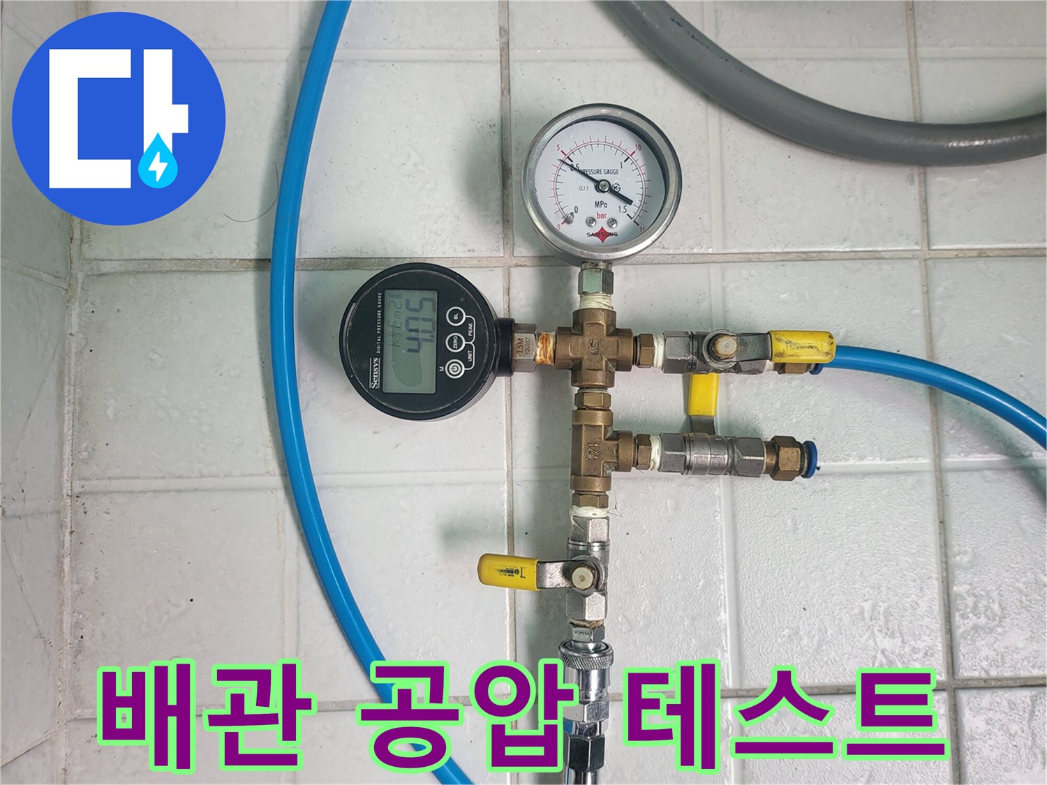 배관 연결 부위에 압력계를 설치하여 수압을 체크하는 장면