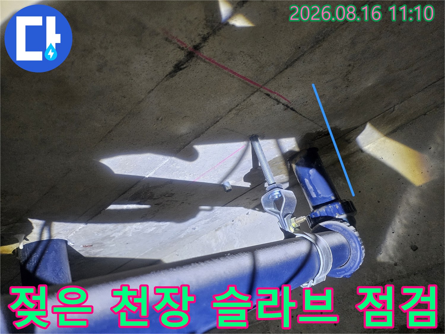 물기가 머문 천장 슬라브와 파란색 배수 배관의 근접 촬영