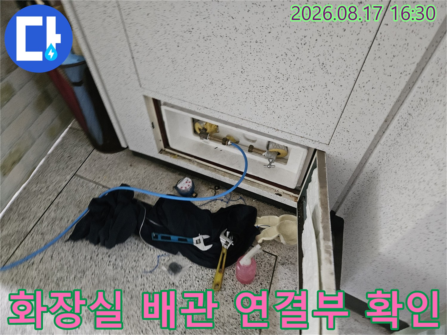 세면대 하부-노출된 수도 부속과 공구 모음