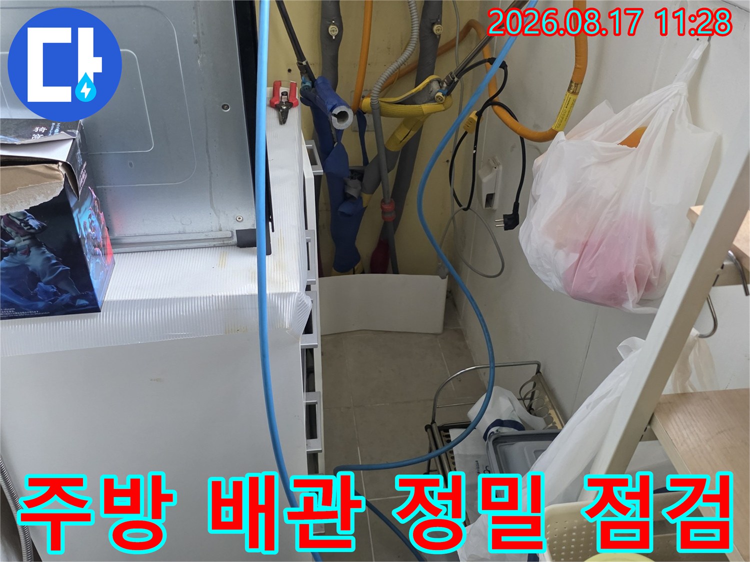 싱크대 아래쪽의 노란색 및 파란색 배관들이 모여 있는 작업 현장입니다.