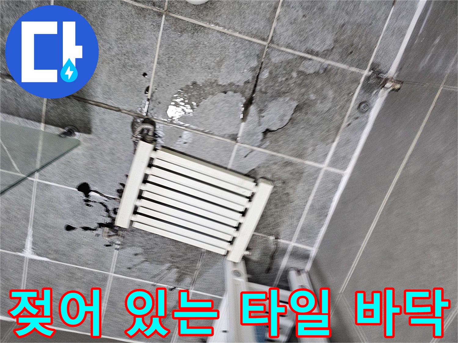분배기 하단 타일 틈새로 물이 스며들어 검게 얼룩진 현장 모습입니다.