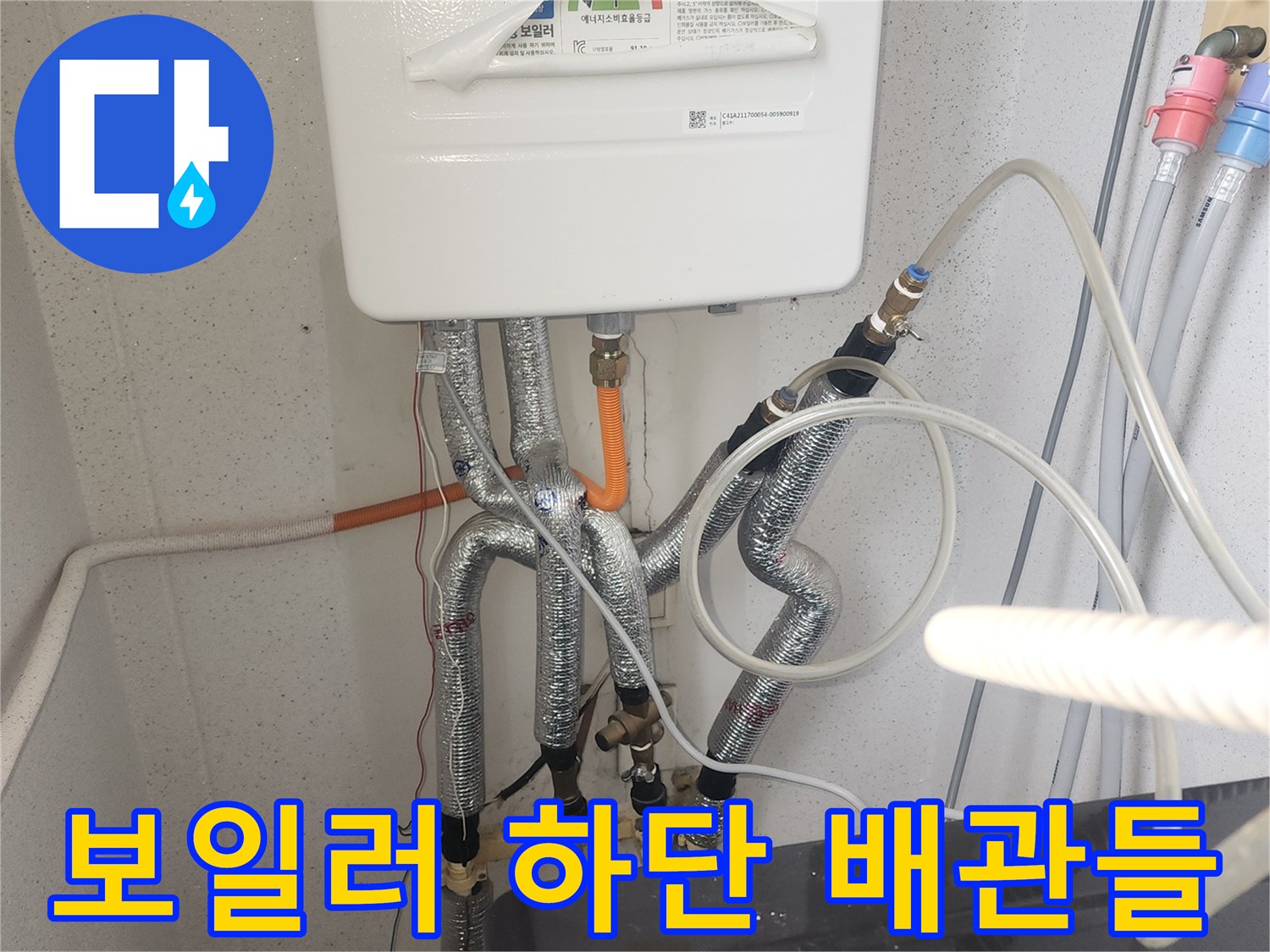 보일러 밑에 연결된 은색 배관과 부속품들