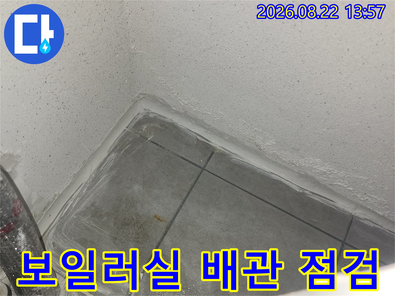 보일러실 바닥 타일 사이의 누수 흔적을 면밀히 조사하고 있습니다.