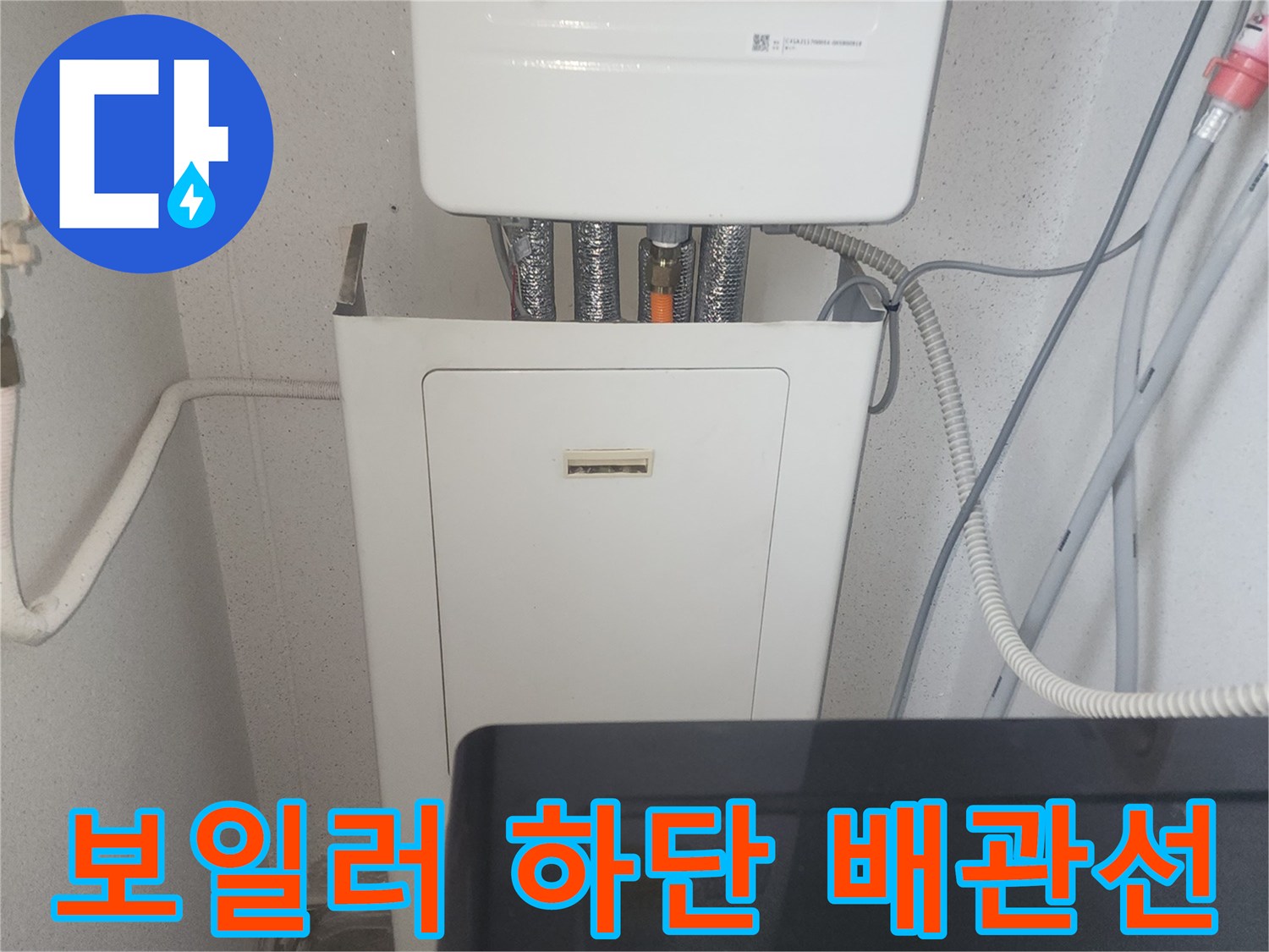 하얀색 보일러 아래쪽으로 연결된 여러 가닥의 배관들
