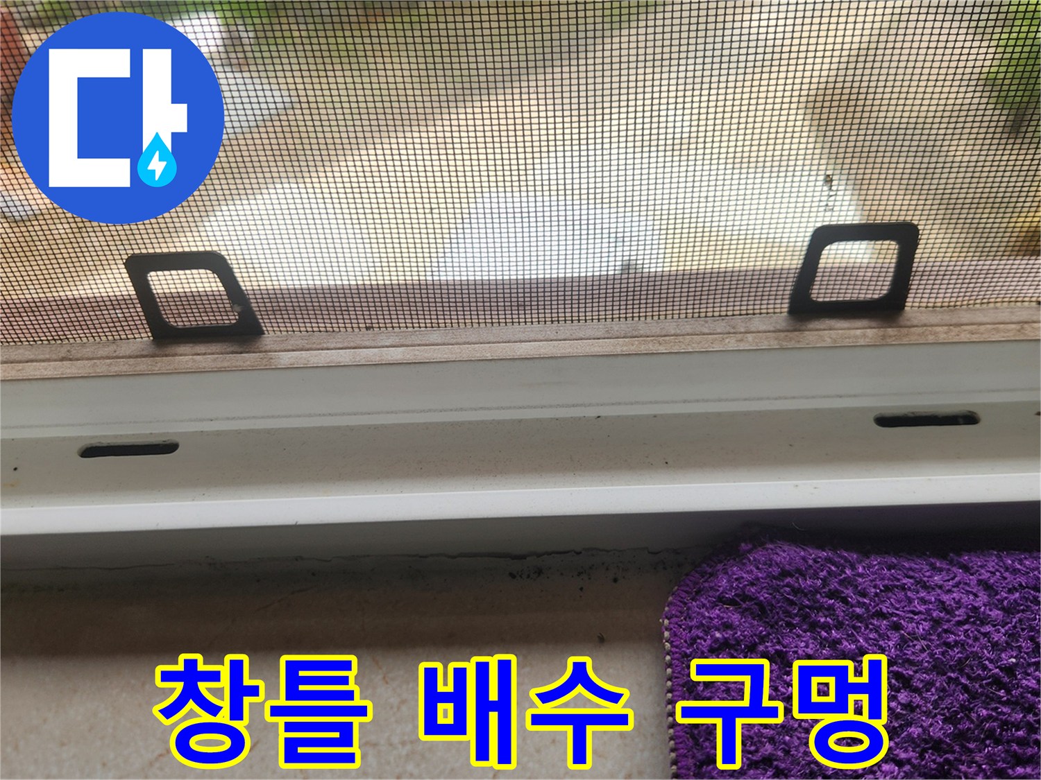 창문 틀 레일의 배수 구멍 부위를 촬영한 사진입니다.