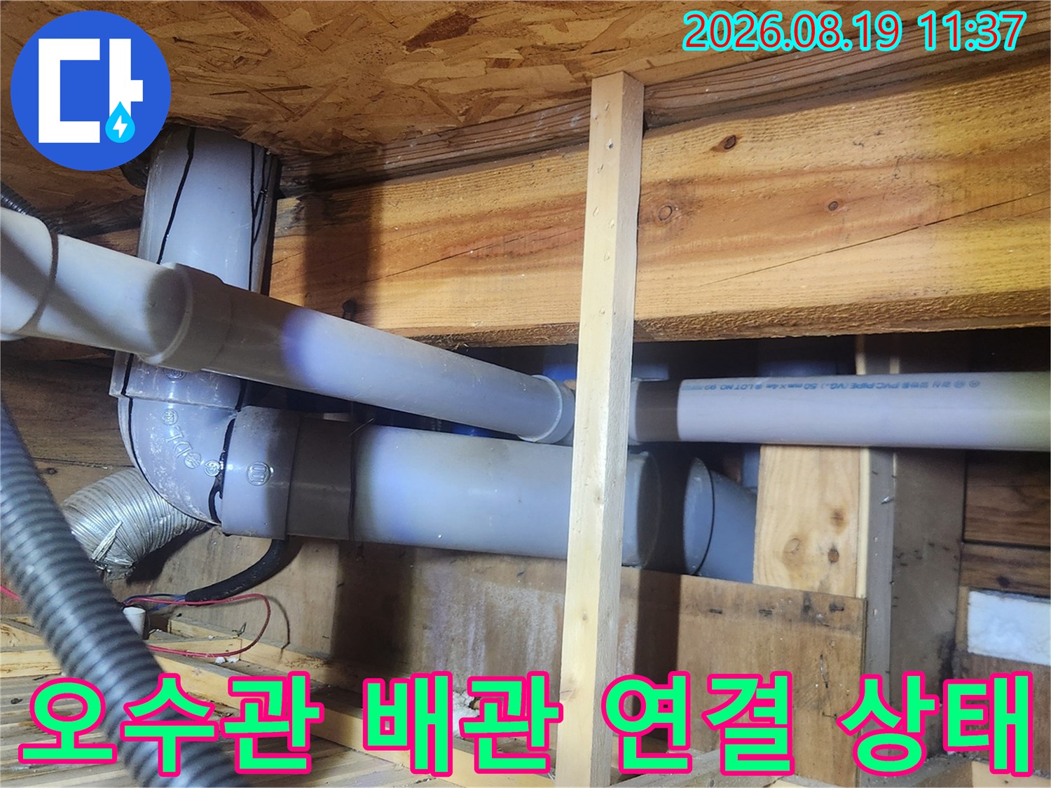 천장 내부 하얀색 오수관과 은색 자재가 연결된 배관 구조물