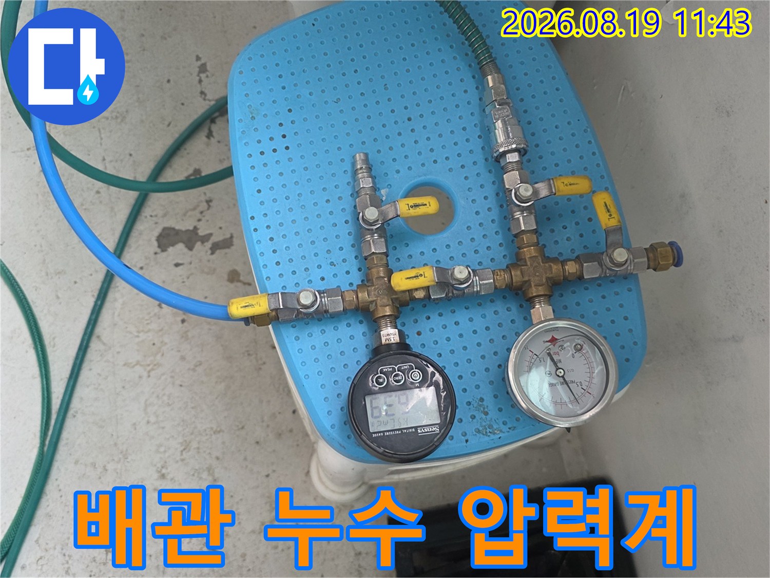 파란색 받침대에 연결된 배관용 압력 측정 게이지