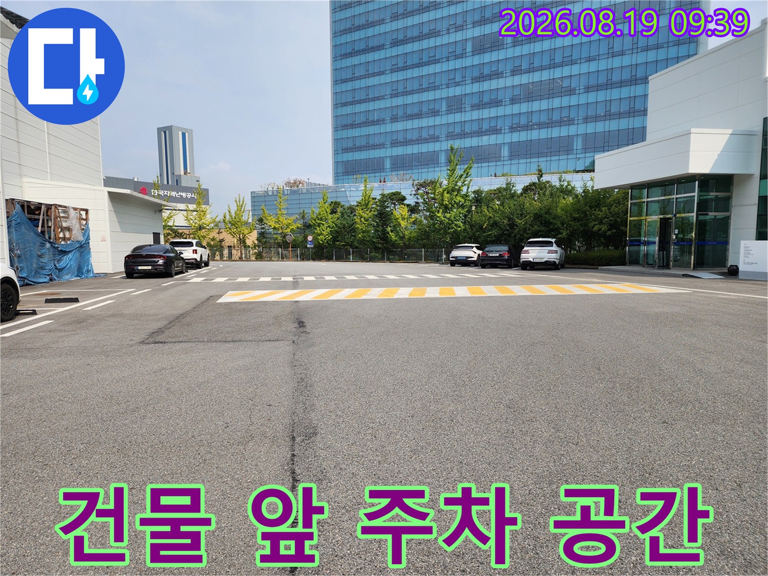 넓은 아스팔트 부지와 현대적인 건물이 보이는 사진입니다.