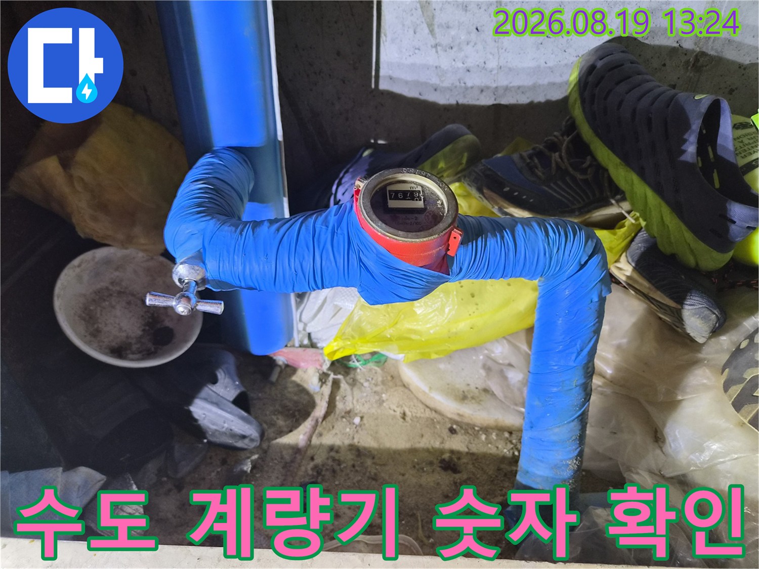 파란색 보온재가 씌워진 배관과 숫자가 보이는 수도 계량기입니다.