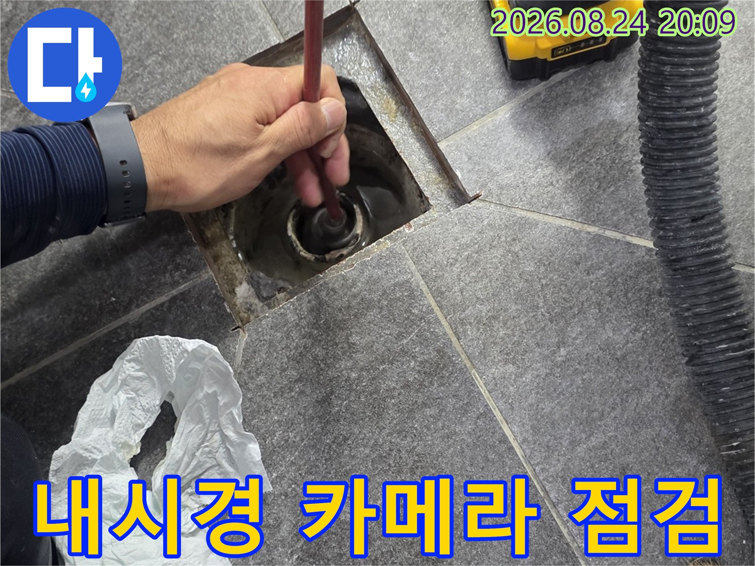 욕실 배수구 내부를 확인하기 위해 내시경 카메라를 투입하는 모습입니다.