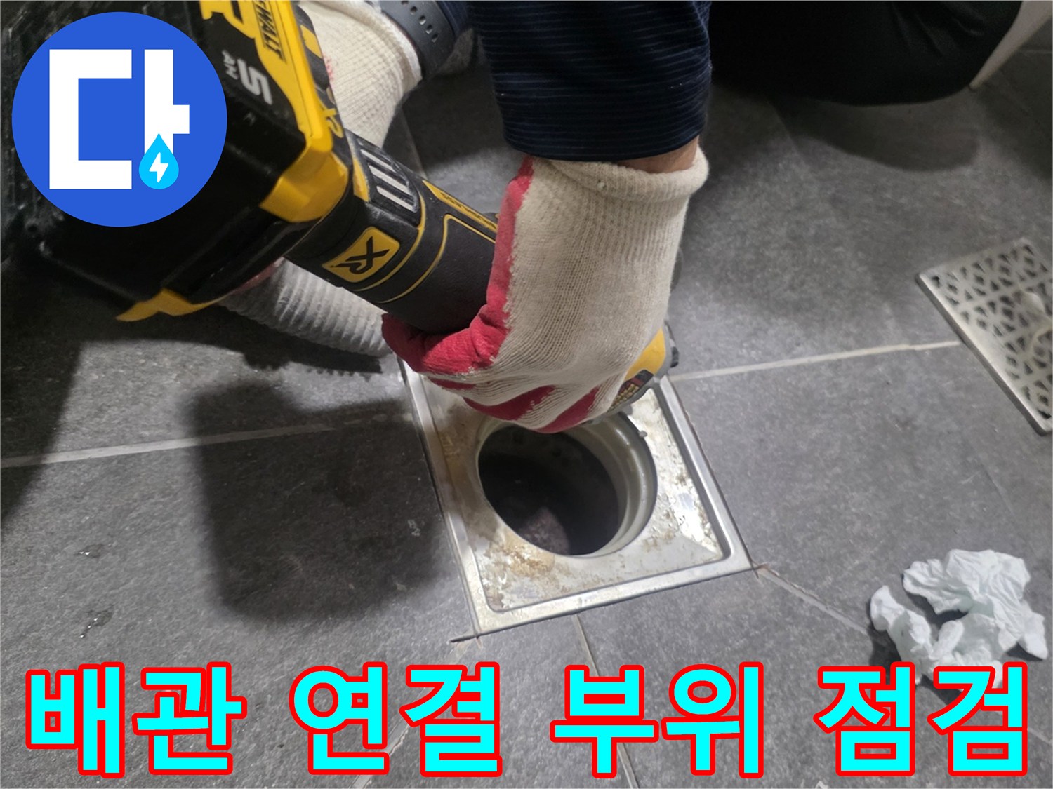 전동 공구를 사용하여 배수구 주변의 타일을 정리하는 중입니다.