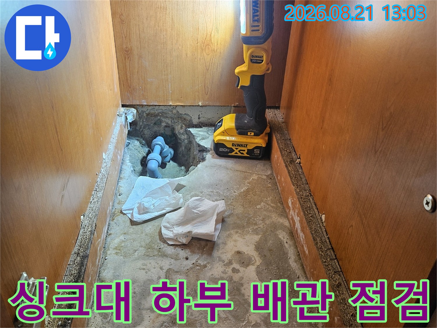 안양 동안구 싱크대 밑 하부장 내부의 배관 누수 상태를 확인하는 장면입니다.