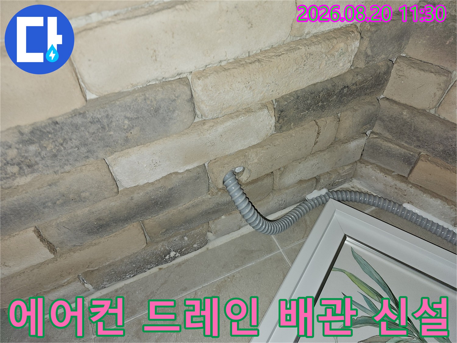 벽면 타공 부위에 새로 설치된 에어컨 드레인 배관 모습