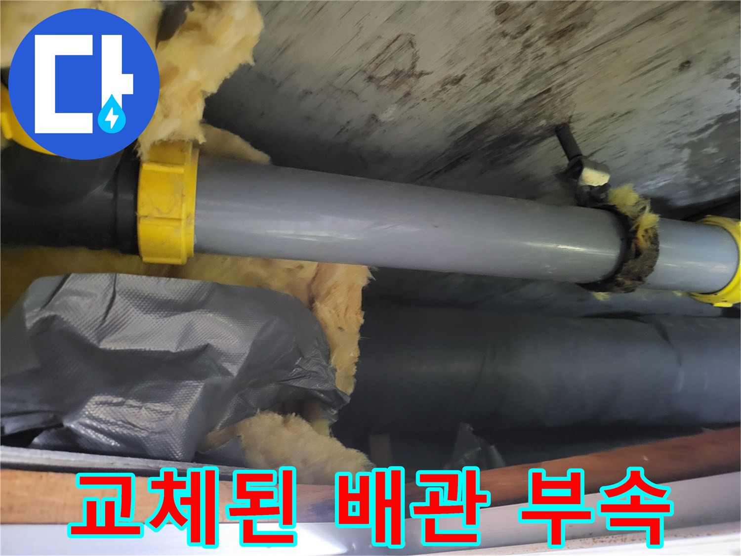 새로운 노란색 부속으로 연결된 회색 배관 모습입니다.