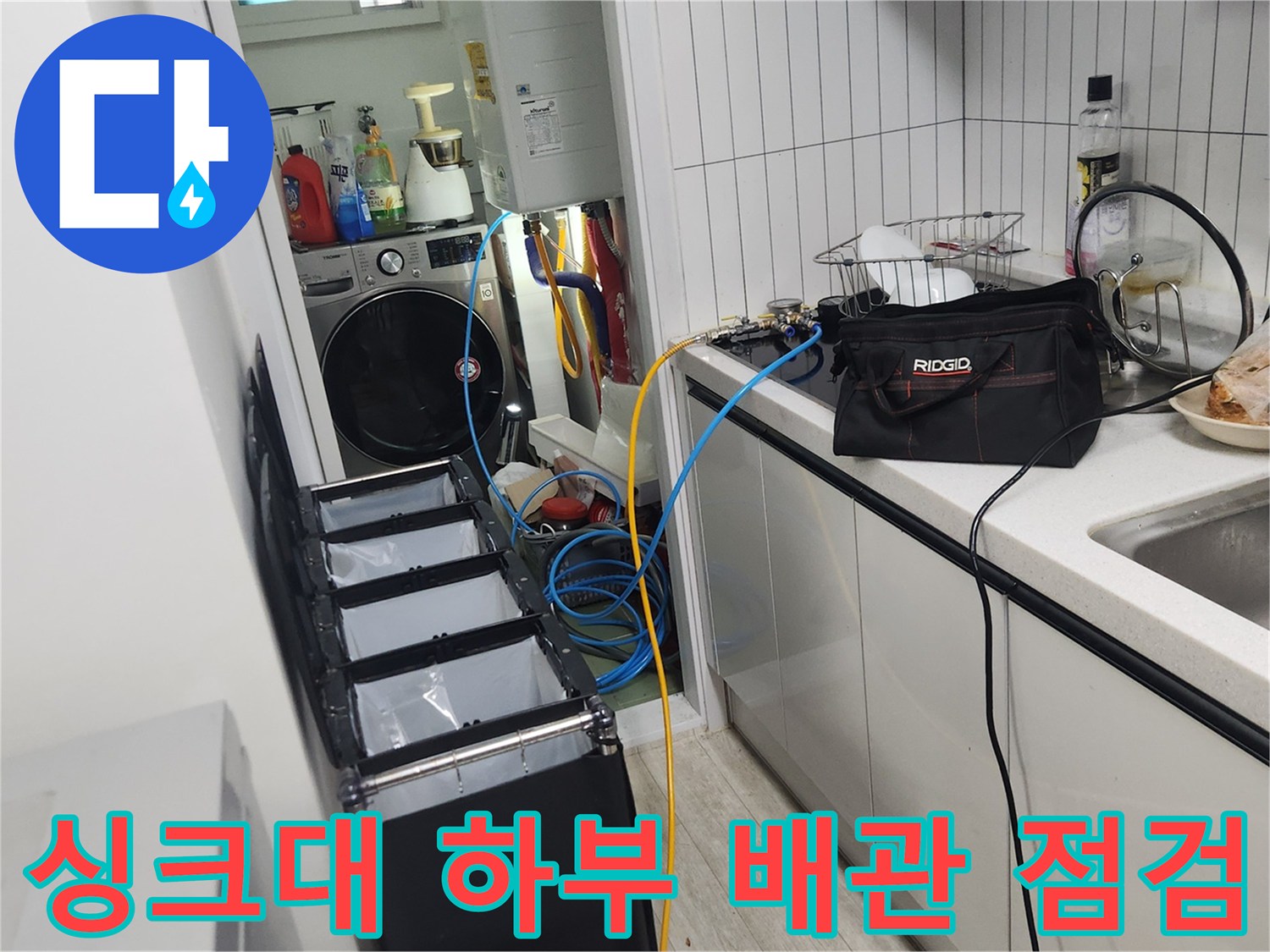 싱크대 밑 보일러 배관에 연결된 공압 검사용 호스와 장비들