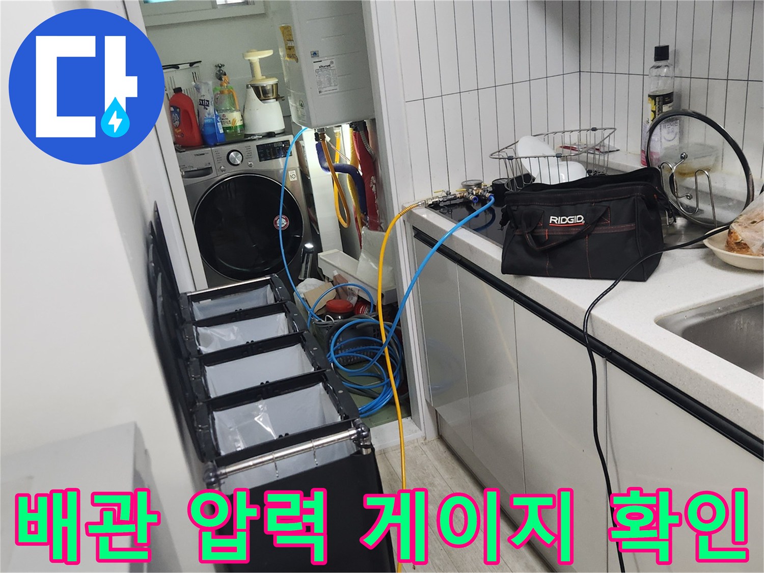 싱크대 하부 배관에 연결된 공압 측정 장치와 압력계 모습