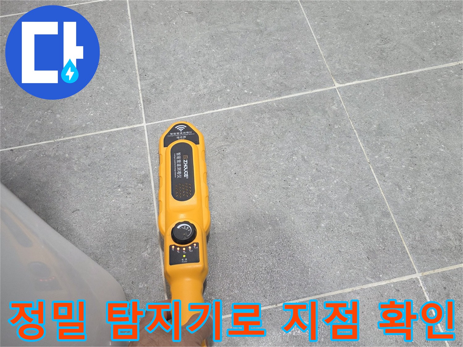 노란색 탐지 장비가-욕실 바닥 위에서-물샘 부위를 스캔함