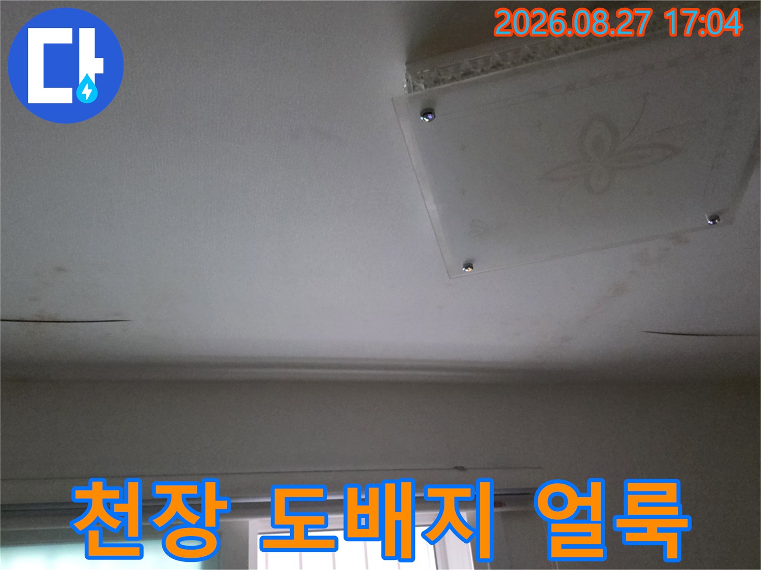 물샘 현상으로 인해 변색된 천장 도배지와 점검구
