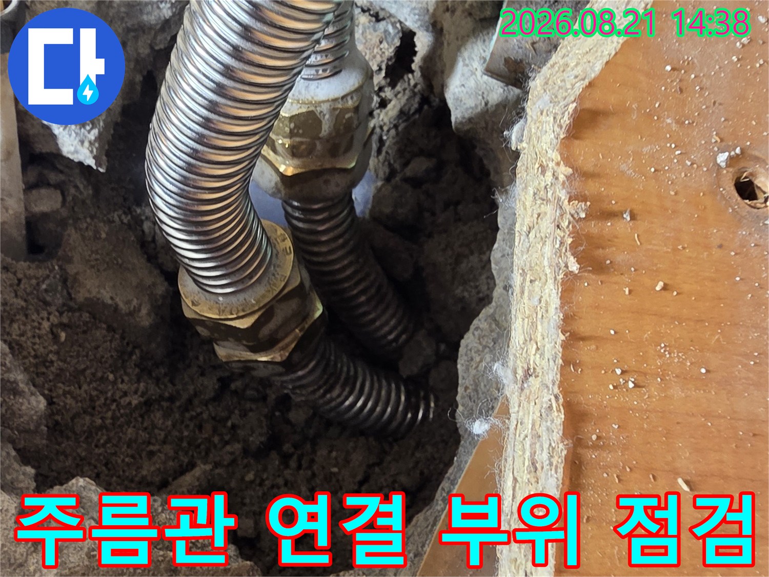 싱크대 아래 흙을 제거하고 드러낸 금속 주름관 연결부입니다.
