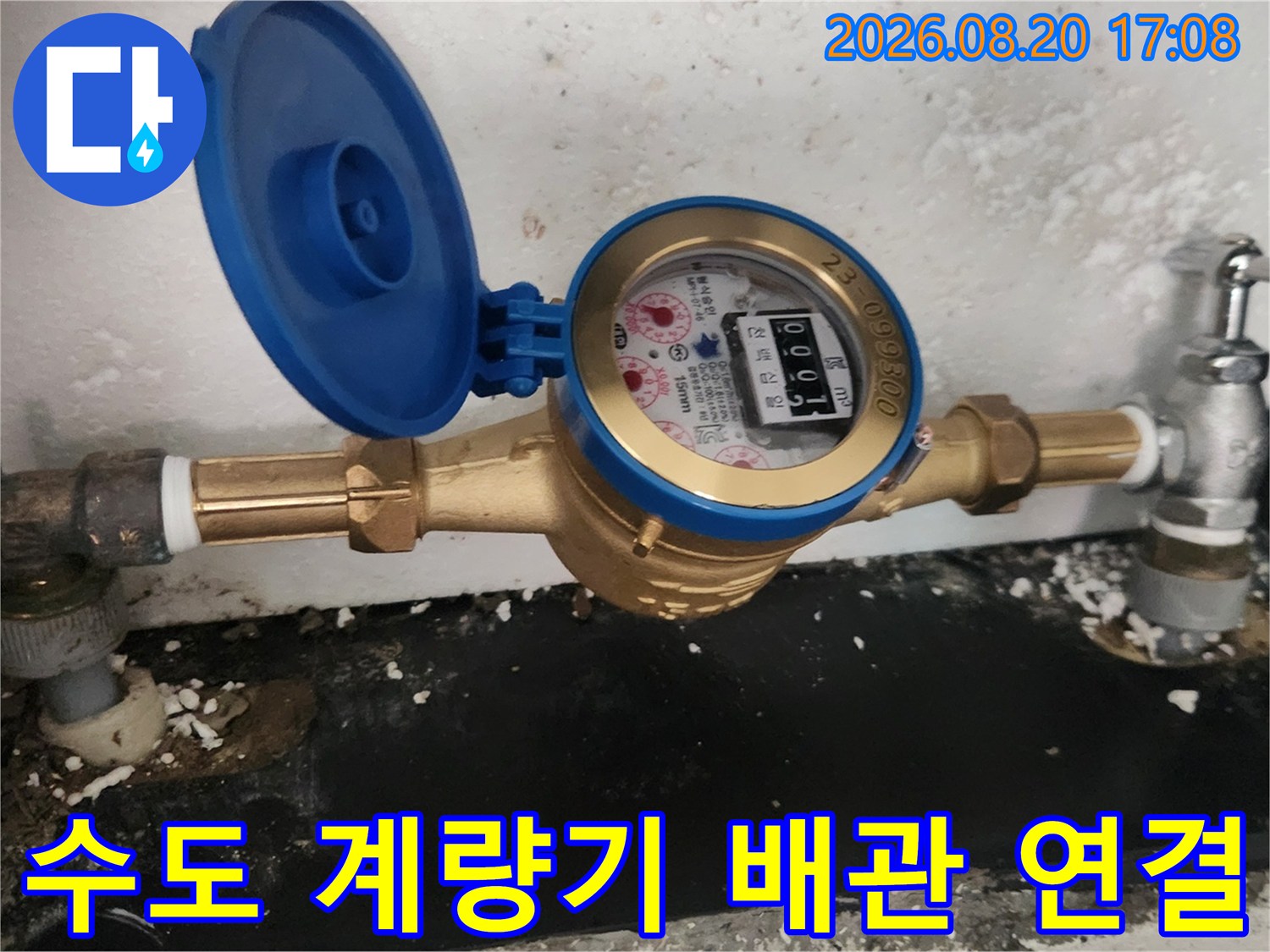 수도 계량기와 금색 배관 부속이 연결된 모습입니다.