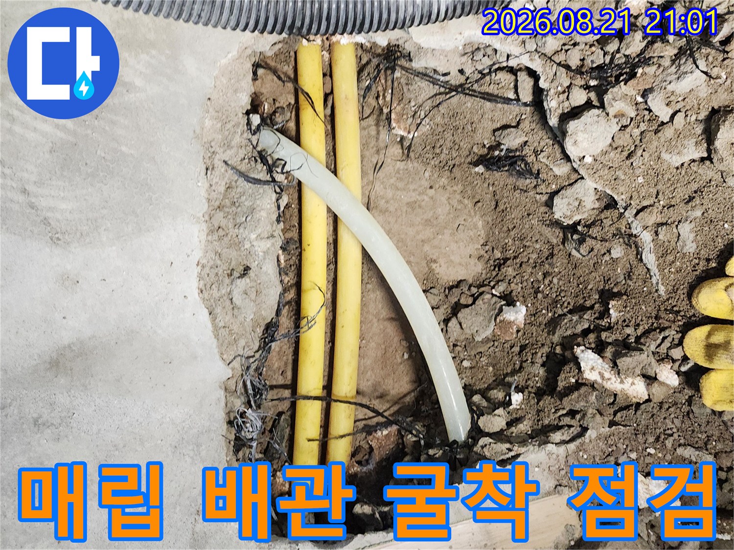 바닥 굴착 후 드러난 노란색 수도 배관과 주변 구조물 상태