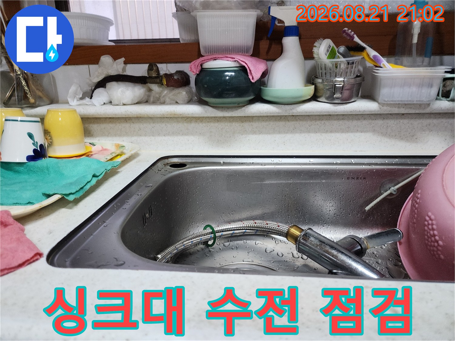 싱크볼 내부에 놓인 수전 헤드와 주변 환경을 촬영한 사진입니다.