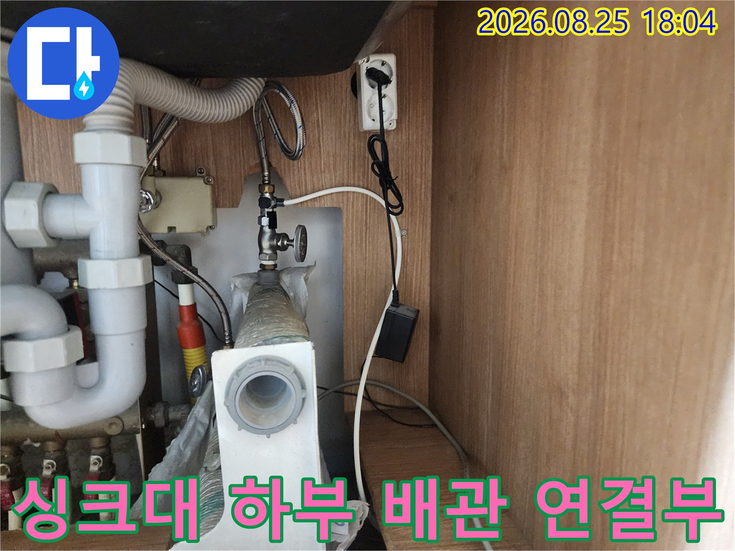싱크대 아래쪽의 흰색 배수 호스와 배관 구조물 상세 사진