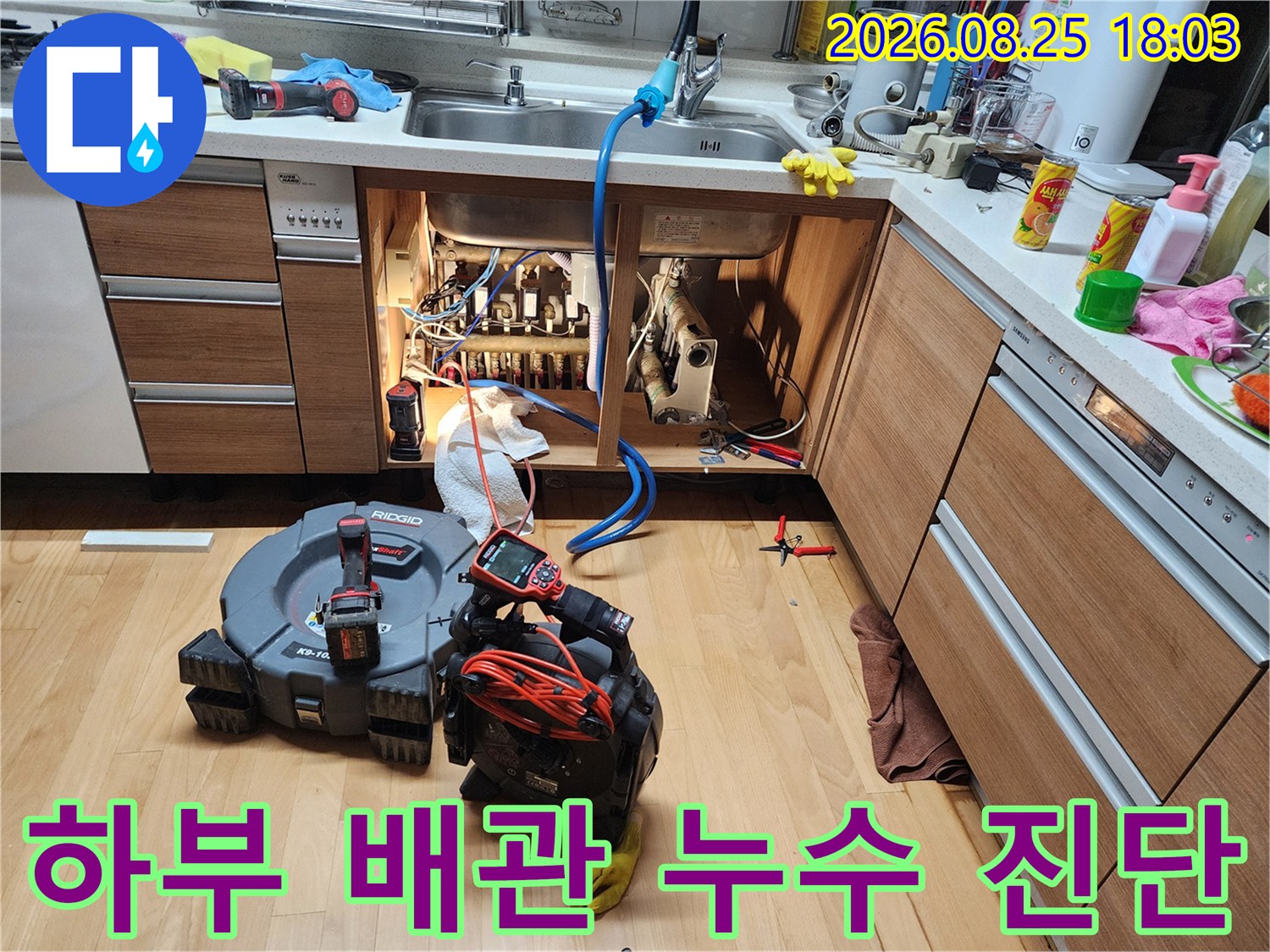 싱크대 하부장의 복잡한 배관들을 하나씩 점검하며 누수를 추적합니다.