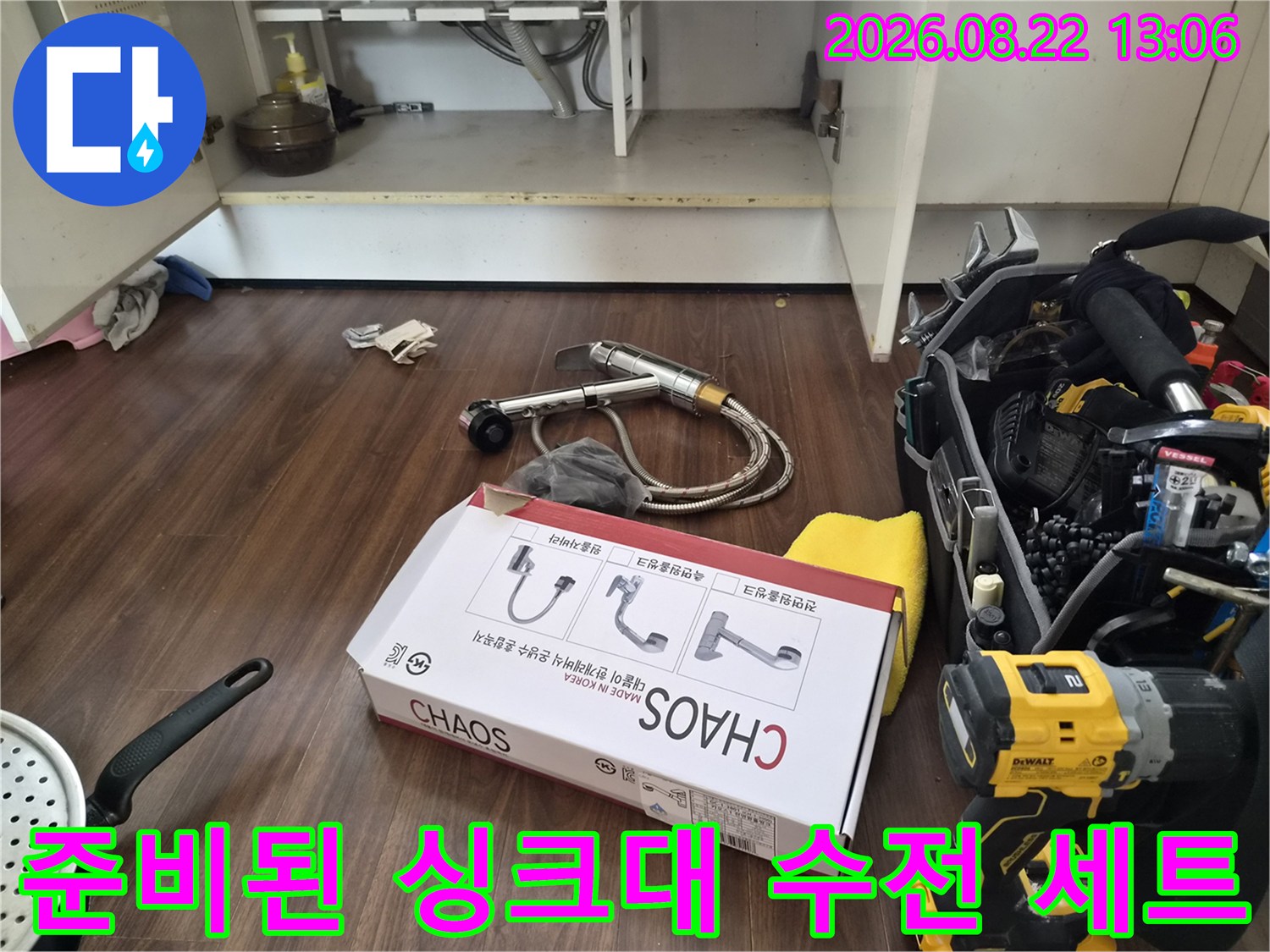 바닥에 놓인 새 수전 박스와 설치를 위한 공구 세트입니다.