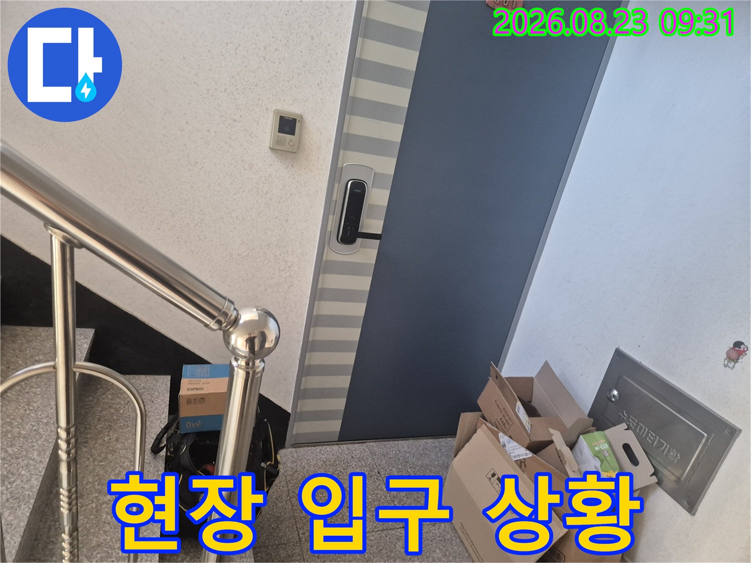 현관문 옆에 자재 상자가 놓여 있는 누수 작업 현장의 모습입니다.