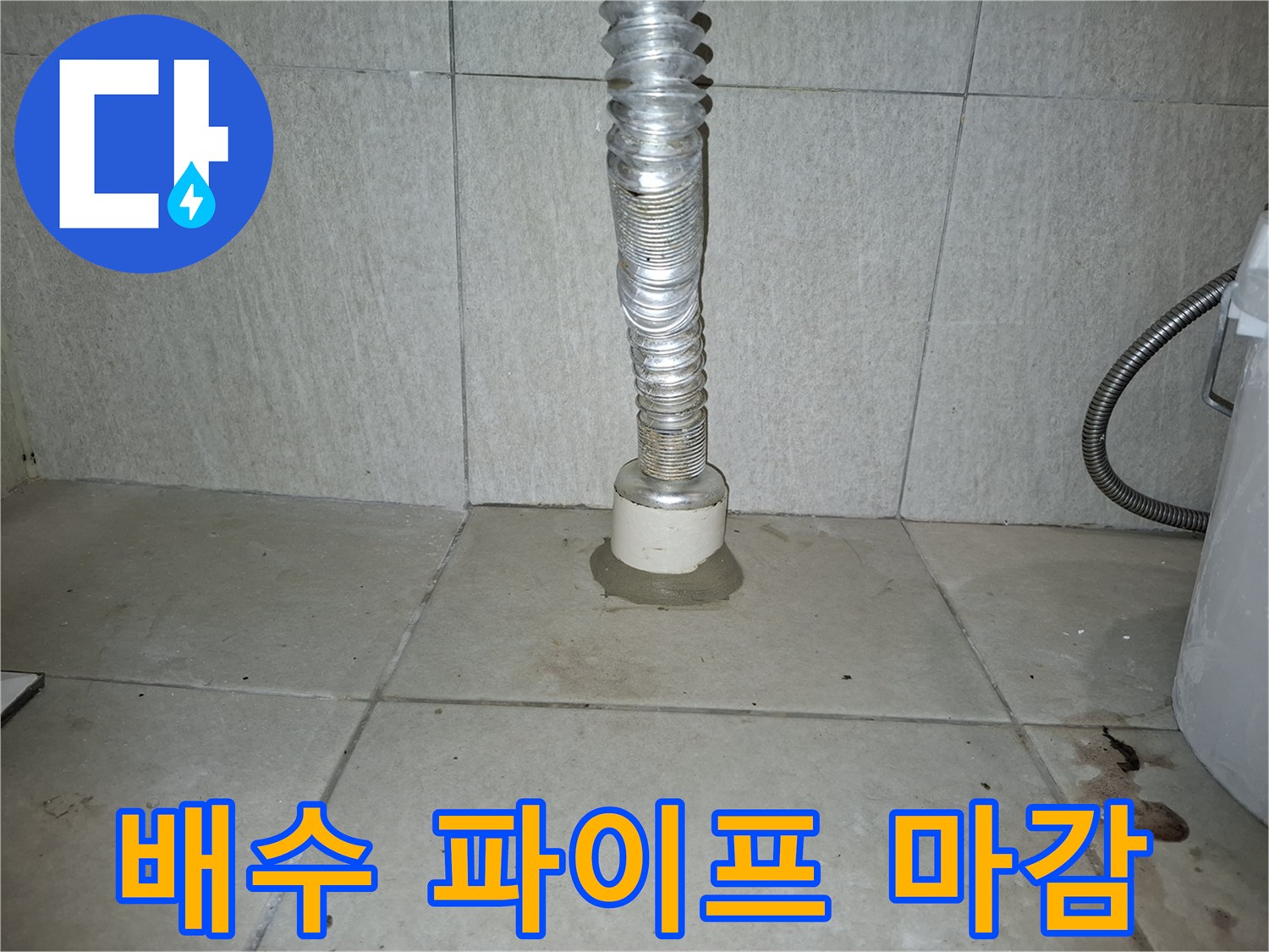 세탁실 배수관과 바닥 타일의 접합 상태를 촬영한 사진