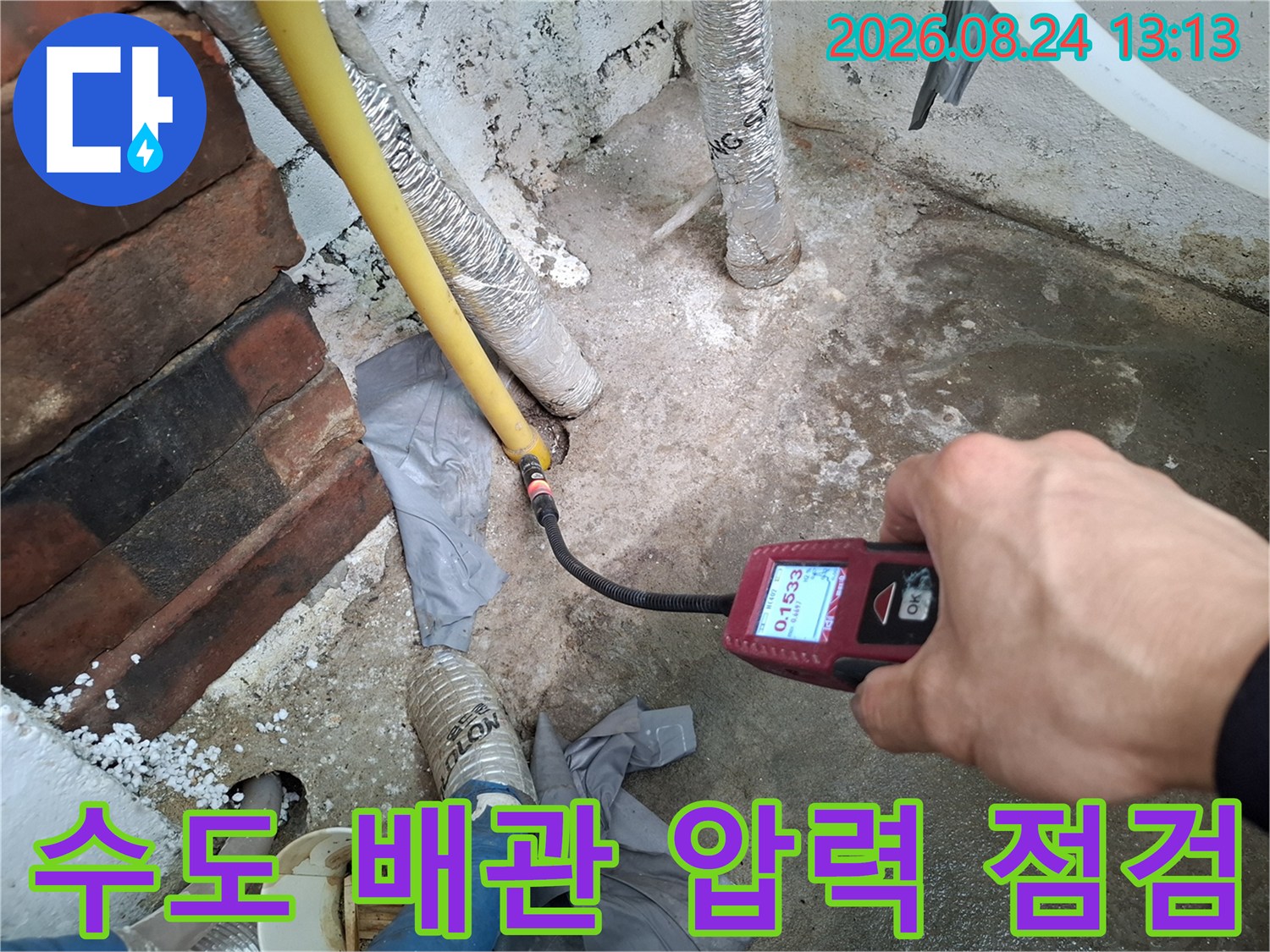 노란색 배관과 연결된 부위의 누수 여부를 디지털 측정기로 정밀하게 진단하는 장면
